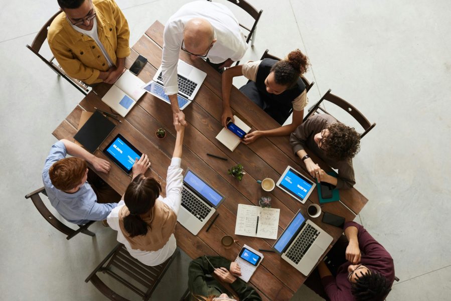 Overhead view of a team collaborating around a wooden meeting table